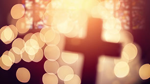 unscharfes Kreuz, mit verschwommenem Hintergrund vom Kirchenfenster mit Lichteinfall